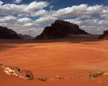 Tourists enjoying Wadi Rum jeep safari with sand dunes, rock formations, and sunset views